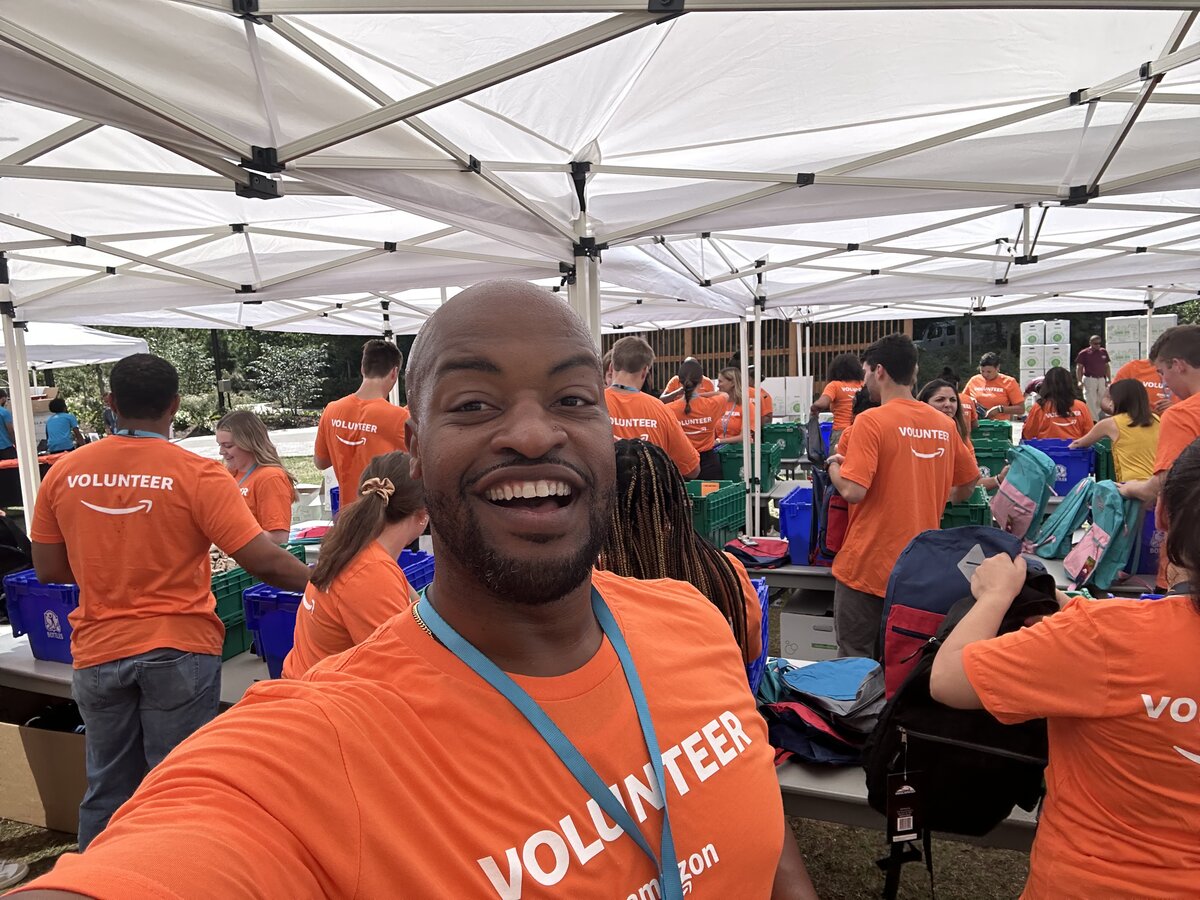 Lucius Williams at an Amazon community volunteer event in orange volunteer shirts