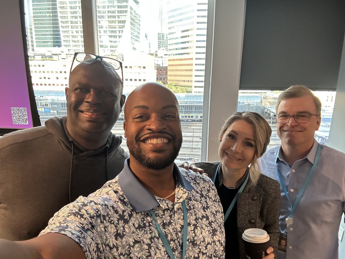 Lucius Williams with colleagues at a conference with city skyline in background