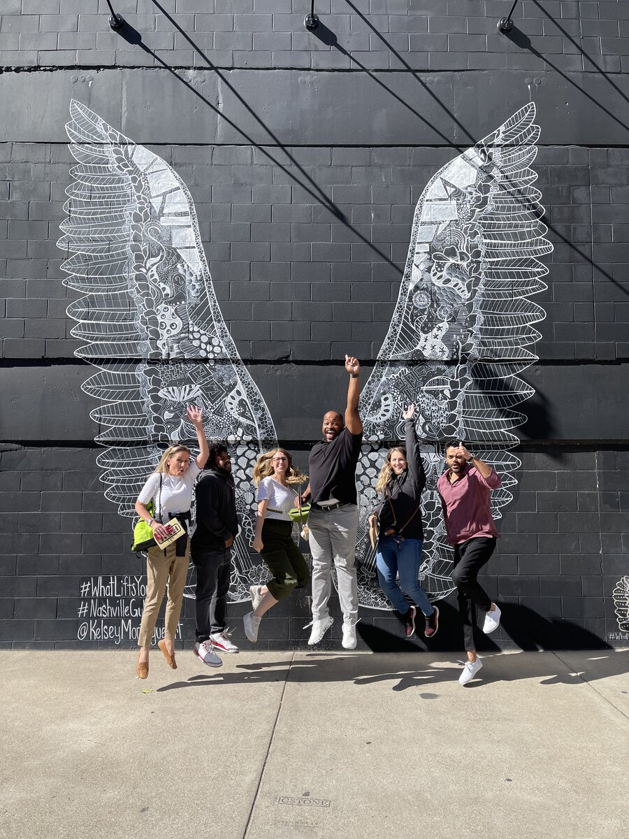 Lucius Williams and friends posing at the Nashville WhatLiftsYou wings mural